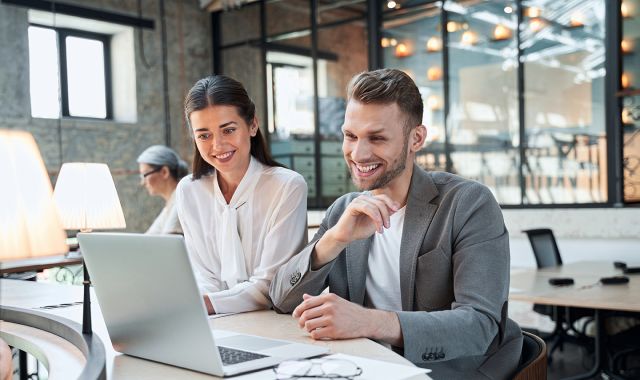 vrouw en man kijken samen op laptop