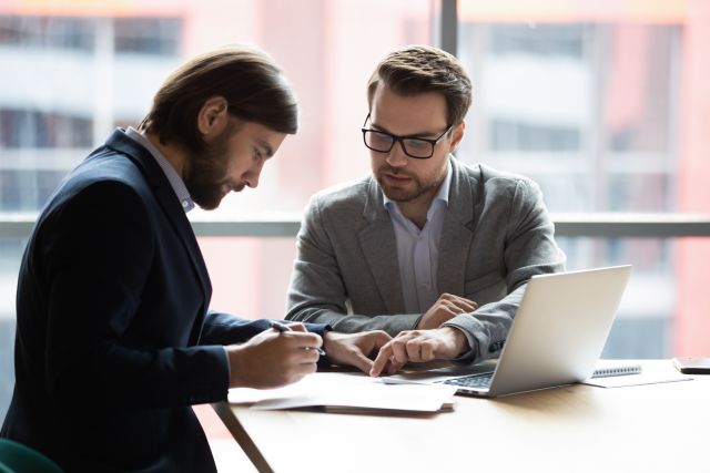 Twee witte mannen ondertekenen document